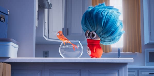 Animated Cat in the Hat character with oversized blue hair and red scarf stands in a kitchen beside a fishbowl, looking at a small orange fish.