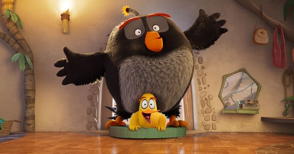 Chuck and Bomb from The Angry Birds Movie 3, with Bomb towering over a smiling Chuck in a tropical room.