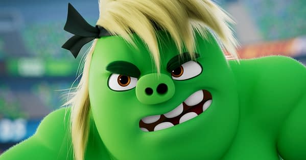 Porkchop, a green Angry Birds character with blond hair and a black bow, glares intensely in a close-up from The Angry Birds Movie 3.