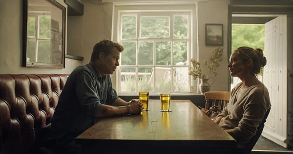 F1: A cozy interior scene of two people sitting at a wooden table in a pub, each with a glass of beer. The man is dressed casually and appears to be engaged in conversation with a woman, who is seated across from him, both illuminated by natural light from a nearby window.