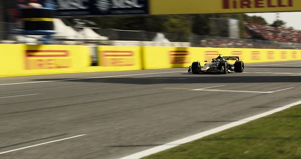 A Formula 1 car speeds past bright yellow barriers at a race track, showcasing intense motion and excitement. The scene captures the thrill of motorsport with blurred backgrounds and a cheering crowd.
