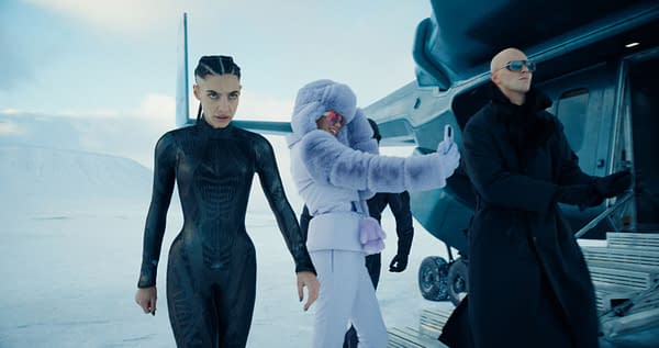 A scene featuring three characters in a snowy, icy landscape, with one woman in a sleek black bodysuit staring intensely at the camera, another woman in a plush purple coat playfully taking a selfie, and a man in a dark coat and sunglasses standing behind them, all near a futuristic aircraft.