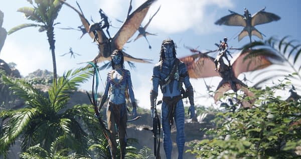 Neytiri and Jake Sully from 'Avatar: Fire and Ash' stand together in a lush, vibrant landscape with flying creatures visible in the background. They are depicted as tall, blue-skinned figures, showcasing an otherworldly aesthetic.
