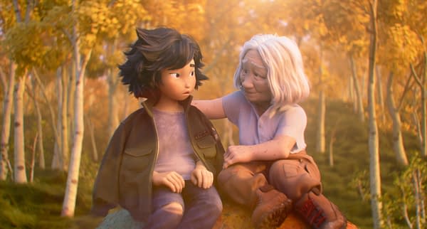 An illustration from Disney and Pixar's "HOPPERS" featuring Mabel, a young girl with dark hair, and Grandma Tanaka, an older woman with light hair, sharing a moment together in a lush autumn forest setting.