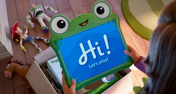 A cartoon scene from 'Toy Story 5' featuring a character named Lilypad, who is holding a colorful tablet displaying the message "Hi! Let's play!" In the background, classic Toy Story toys like Buzz Lightyear and Jessie are scattered on the floor.