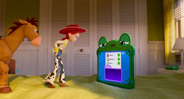 Bullseye, Jessie, and Lilypad from Disney and Pixar's Toy Story 5 stand on a bed facing a frog-shaped tablet displaying a friends list.