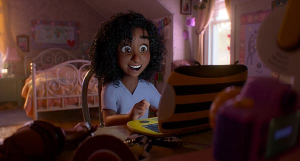 Blaze, a smiling animated girl, sits at a desk in a pink bedroom facing a small yellow laptop in Disney and Pixar's Toy Story 5.