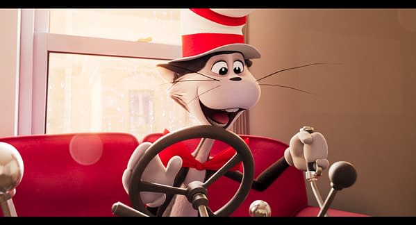 A cheerful animated cat wearing a tall red and white striped hat is sitting at the wheel of a car, smiling widely. The car's interior is bright red, with a window showing raindrops in the background.