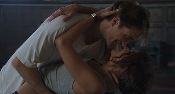 A romantic scene from A24's drama film, featuring a man and woman leaning in for an intimate moment, showcasing their emotional connection in a softly lit space.