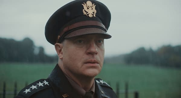 Brendan Fraser portrays General Dwight D. Eisenhower in a dramatic scene from the 2026 film 'PRESSURE,' directed by Anthony Maras. The background features a blurred, overcast landscape.