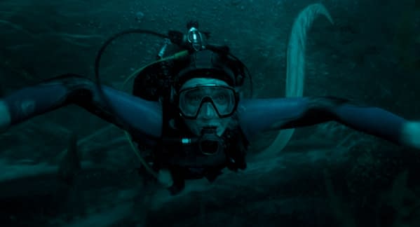 Austin Abrams as Jay Gardiner underwater in Whalefall, wearing a scuba mask and spread out amid dark blue water.