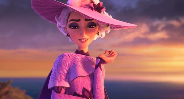 Queen Celeste from Disney's Hexed stands in a pink hat and elegant gown at sunset, smiling against a dramatic sky.
