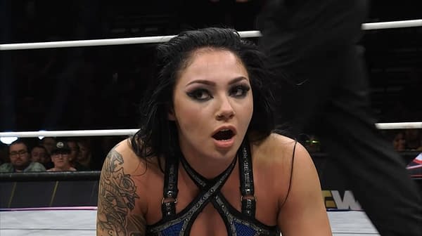 Skye Blue, a wrestler from the Sisters of Sin, shows a shocked expression while reacting to a pin attempt during an AEW Collision match. The wrestling ring is visible in the background.