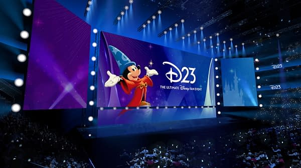 D23 stage at the Honda Center with Mickey Mouse in Sorcerer's Apprentice costume and a large Disney fan event backdrop, lit in blue and purple.