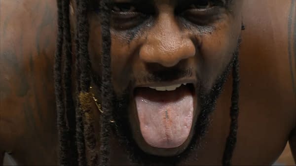 A close-up of wrestler Swerve Strickland at AEW Double or Nothing, displaying a tongue with a staple embedded in it, showcasing the aftermath of Anarchy in the Arena, a hardcorea wrestling match.