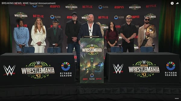 A press conference announcing WWE WrestleMania 43 taking place in Saudi Arabia, featuring several individuals standing behind a podium adorned with the event's logo and branding.