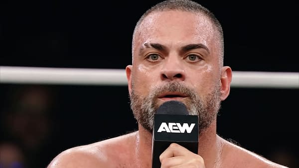 Eddie Kingston delivers an emotional promo in a wrestling ring, holding a microphone and appearing visibly intense and passionate.