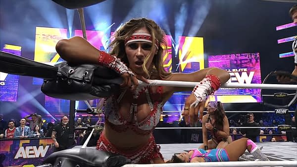A wrestler from The Divine Dominion is celebrating a victory in the ring, gripping the ropes with determination. In the background, another wrestler is down, and fans are cheering in a vibrant arena filled with colorful lights.