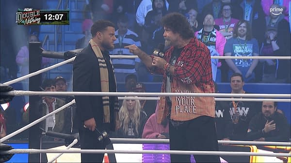 Mick Foley points a finger at MJF during a heated microphone exchange in the AEW ring at Double or Nothing. The crowd watches as the two wrestlers face off during the Buy-In pre-show.
