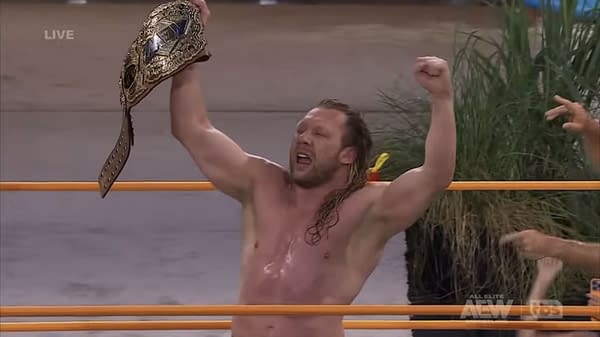 Kenny Omega raises the AEW Championship overhead in celebration after winning the title at Beach Break.