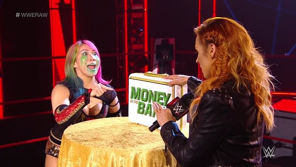 Becky Lynch presents the WWE Raw Women's Championship to Asuka.