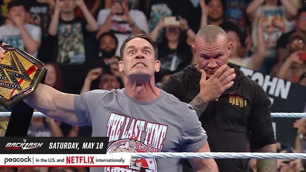 John Cena, displaying an intense expression while holding the WWE Championship belt, is confronted by Randy Orton, who stands in the background looking ready to ambush him. The crowd is energized in the background on WWE SmackDown ahead of WWE Backlash.