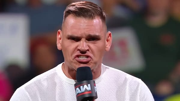 Gunther passionately delivers a promo on WWE Raw, holding a microphone and showcasing an intense expression. The audience is visible in the blurred background, creating a lively atmosphere.