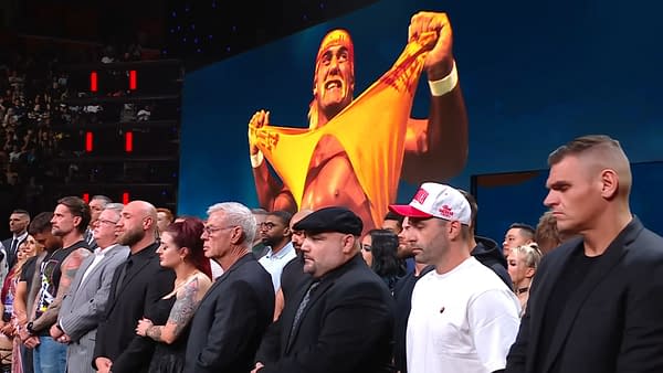 A group of WWE Superstars and Legends, including CM Punk, stands in tribute during a solemn moment on WWE Raw, with an iconic image of Hulk Hogan displayed behind them.