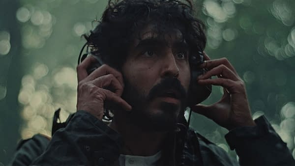 Dev Patel with headphones appears distressed in a forest setting in the film 'Rabbit Trap', featured at the 2025 Sundance Film Festival.