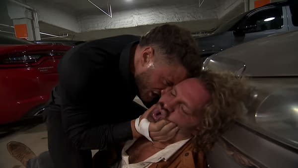 In a dimly lit parking garage, MJF aggressively assaults Hangman Adam Page, pinning him against a car. Page appears vulnerable as MJF grips his face forcefully in this segment that aired on AEW Dynamite.