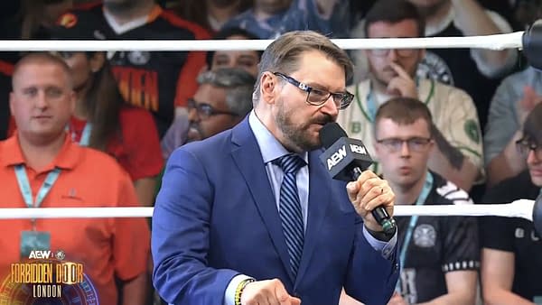 Tony Schiavone, wearing a blue suit and glasses, announces the record-breaking attendance at the AEW Forbidden Door event in London, speaking into a microphone while a diverse crowd is visible in the background.