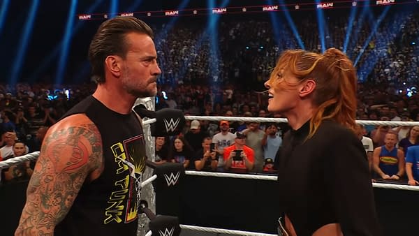 Becky Lynch confronts CM Punk at WWE Raw, both showcasing intense expressions in the ring. The audience is engaged and visible in the background.