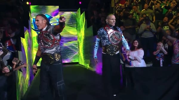 The Hardys make their entrance at TNA Bound for Glory, showcasing their championship belts while engaging with the excited crowd in a vibrant arena.