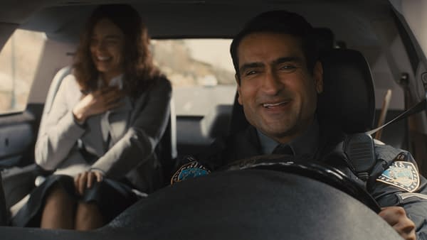 In a scene from 20th Century Studios' 'Ella McCay', Emma Mackey as Ella McCay shares a joyful moment with Kumail Nanjiani, who's portraying Trooper Nash, while seated in a police vehicle.
