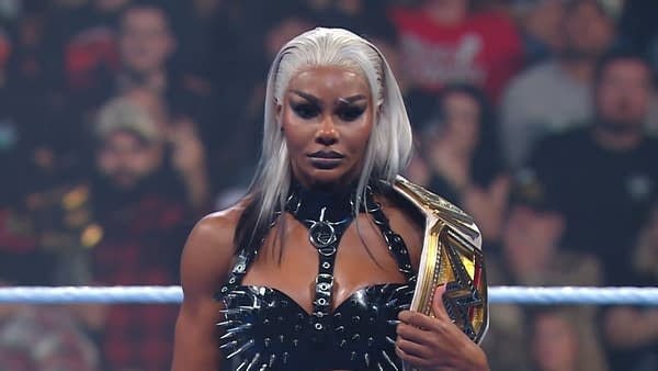 Jade Cargill poses confidently on WWE SmackDown, wearing a black spiked outfit and holding a championship belt, amidst an engaged crowd.
