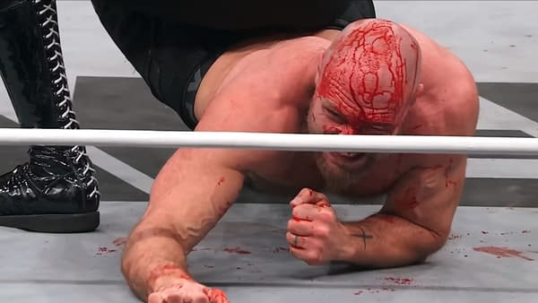 Jon Moxley, visibly injured and bleeding, struggles on the mat during a Continental Classic match against Claudio Castagnoli on AEW Dynamite, showcasing an intense moment of wrestling.