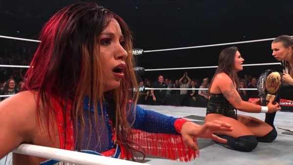 Mercedes Moné shows a shocked expression after losing her RevPro title to Alex Windsor at the AEW Collision Holiday Bash, set in a wrestling ring with spectators in the background.
