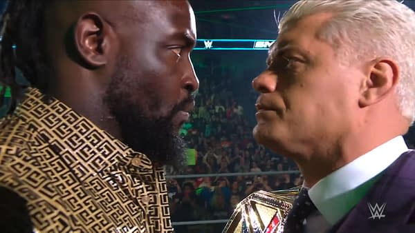 Oba Femi and Cody Rhodes engage in an intense face-off during WWE SmackDown, highlighting their upcoming match at Saturday Night's Main Event. The focus is on their determined expressions and body language.