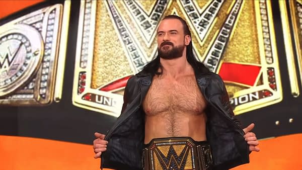 Drew McIntyre stands on stage revealing his championship title belt while wearing a leather jacket during a WWE SmackDown event. The background features the WWE logo and championship design elements.