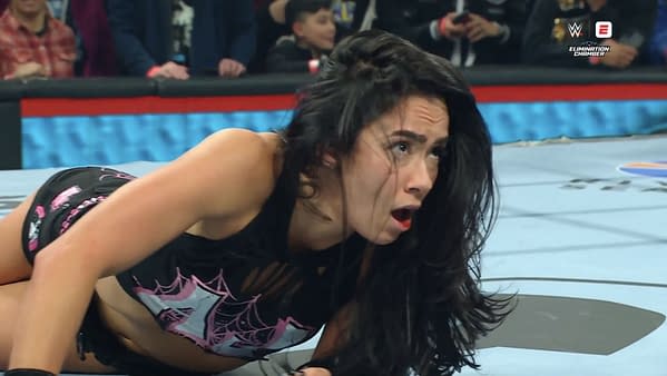 AJ Lee shows a passionate expression as she celebrates defeating Becky Lynch to win the Intercontinental Championship at the WWE Elimination Chamber event, capturing the emotional moment in the wrestling ring.