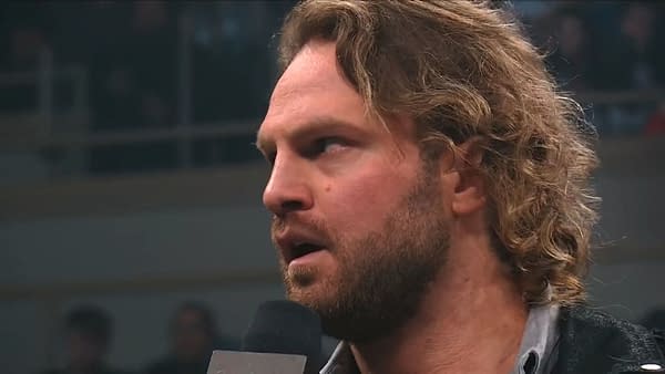 Hangman Adam Page stands in the ring during AEW Dynamite, addressing the audience with a serious expression as he makes a startling promise.