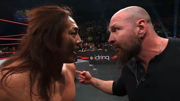 Konosuke Takeshita and Jon Moxley face each other intensely in the ring during AEW Collision, showcasing a confrontation filled with emotion. The backdrop features a wrestling ring and an audience in the stands.