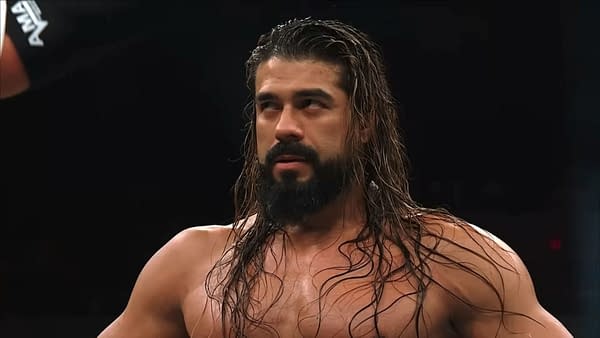 Andrade stands in the AEW ring with a stern, unamused expression after a hard-fought moment. His wet hair and intense stare suggest frustration on AEW Collision.