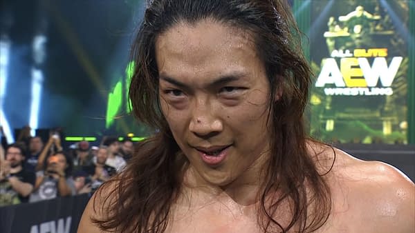 Konosuke Takeshita, a muscular wrestler with long hair, shows a serious expression as he surveys the damage after betraying his partner, Kazuchika Okada, during the AEW Dynasty event. The background features an AEW logo and an energetic crowd.
