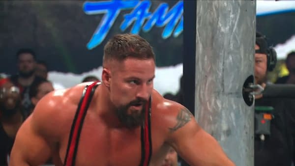 Bron Breakker crouches and prepares to launch a spear outside the ring at WWE Backlash. He looks intense and focused beside the ring post.