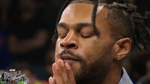 Kevin Knight closes his eyes and presses his hands to his face in a dramatic AEW Double or Nothing close-up.