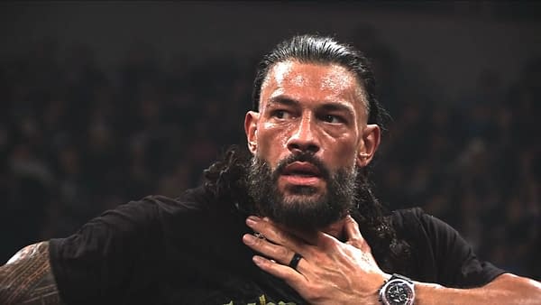 Roman Reigns looks stunned and clutching his neck during a tense moment after an attack by Jacob Fatu.