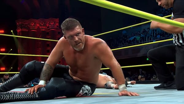Steve Maclin sits on the mat during a TNA Championship match on Impact, with a referee nearby and the crowd in the background.