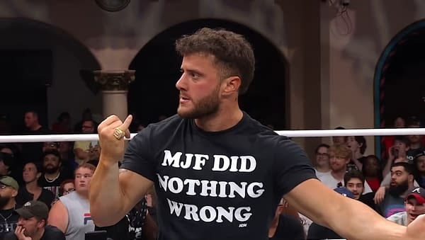A wrestler wearing a black shirt with the phrase "MJF DID NOTHING WRONG" gestures animatedly while other fans are visible in the background on AEW Dynamite. The scene captures the intensity and excitement of a live wrestling event.