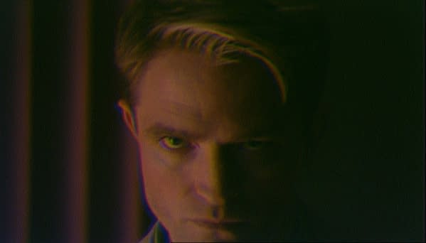 Close-up of a man's face in dramatic shadow with a tense, serious expression, styled like a promotional still from Primetime.